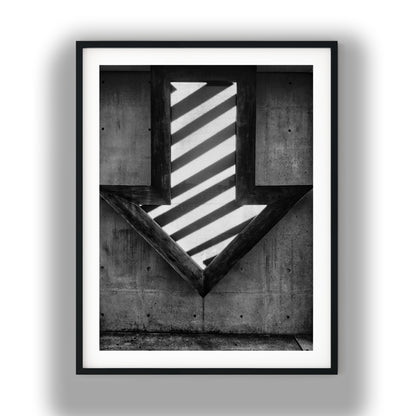 Illuminated Geometric Down Arrow on Textured Concrete Wall Black and White Print