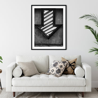 Illuminated Geometric Down Arrow on Textured Concrete Wall Black and White Print